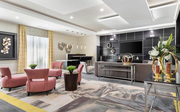 Holiday Inn Express Suites Anaheim lobby A photo of the lobby at Holiday Inn Express Suites Anaheim Resorts Area shows a seating area that includes a couch, 4 chairs, and a bar top area for dining.