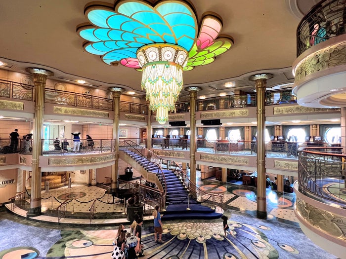 Family getting photo taken on Disney Cruise Lobby atrium on Disney Fantasy