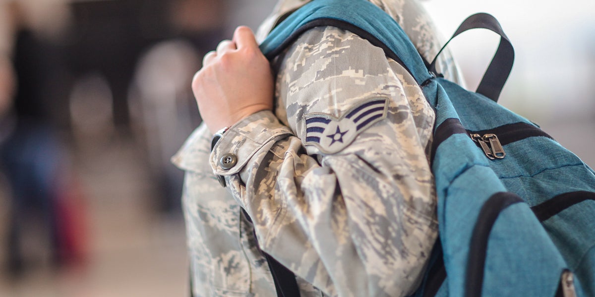 Military woman in airport holds bag