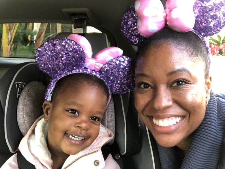 Ashley and her daughter don matching Minnie Mouse ears before heading into Disneyland.