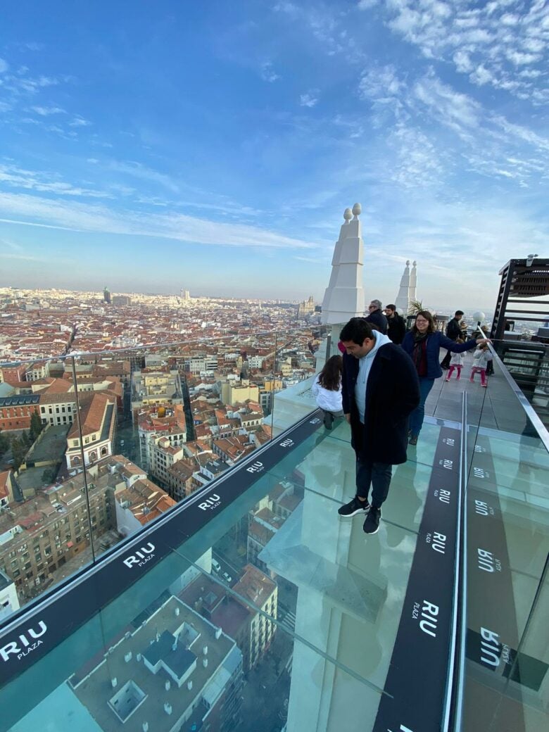 Inspecting the glass-bottom rooftop bridge atop a hotel in Madrid, Spain.