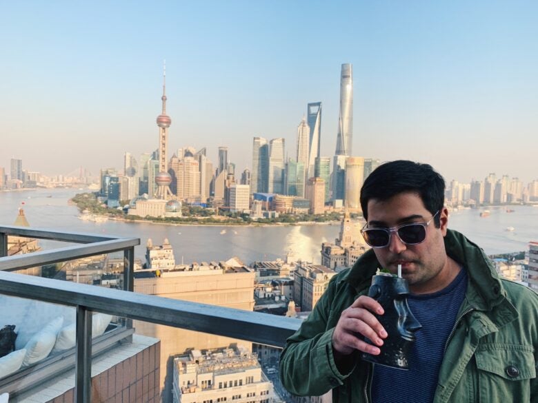 Enjoying a rooftop beverage on The Bund in Shanghai, China, with the Pudong skyline in the background.