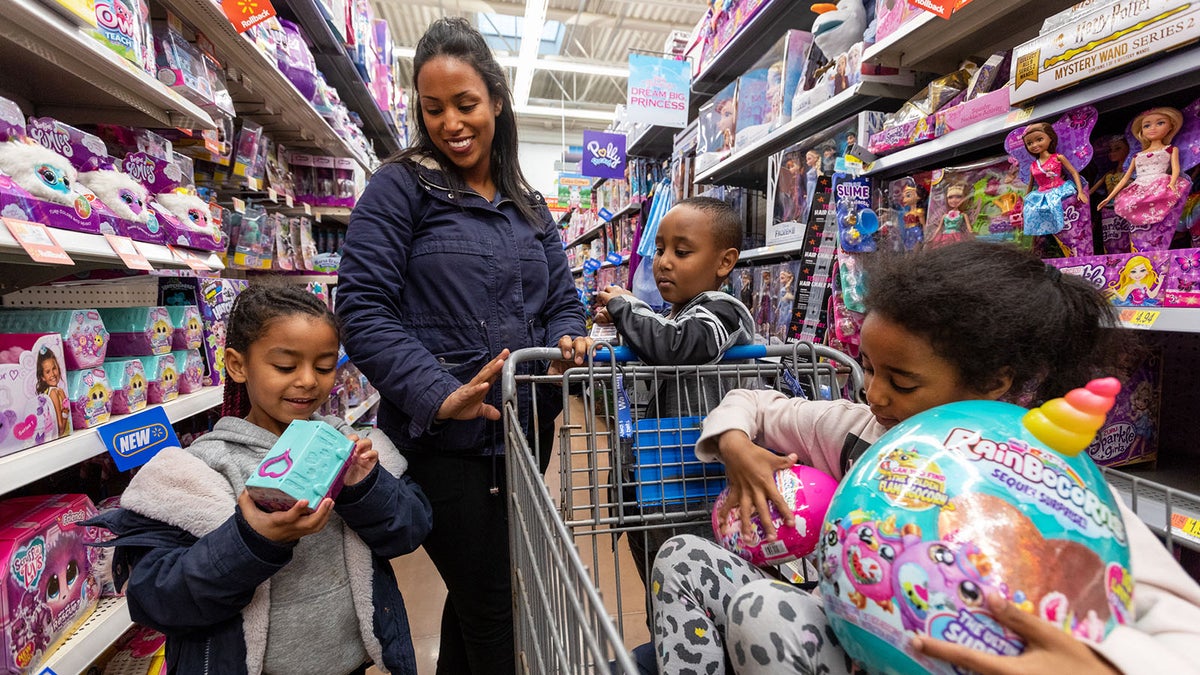 a family checks out new holiday toys in a walmart store aisle