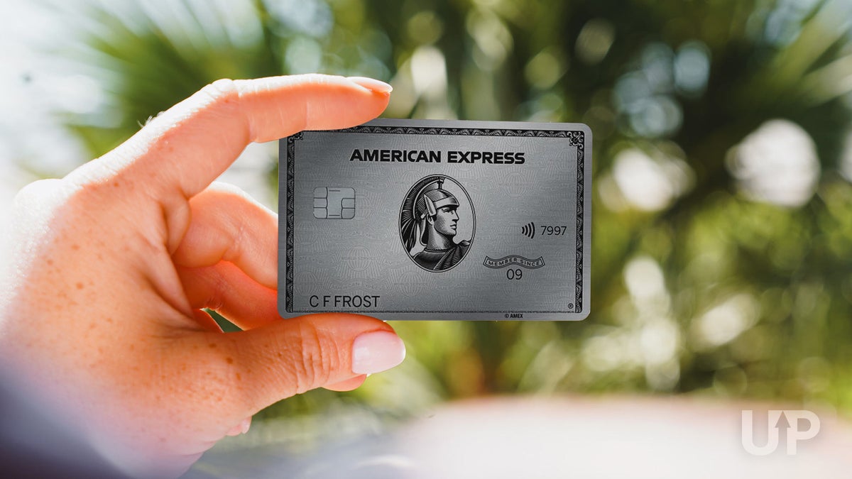 A hand holding an Amex Platinum card