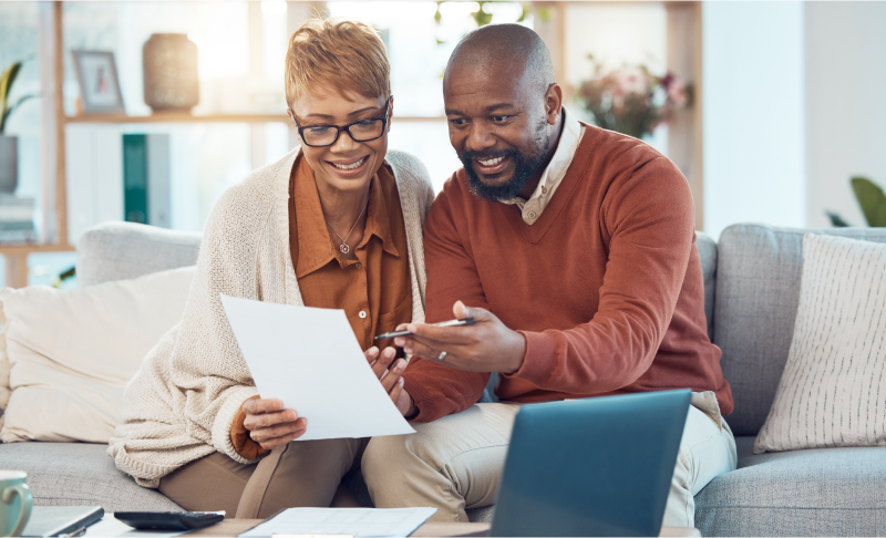 Couple reviewing paperwork at laptop