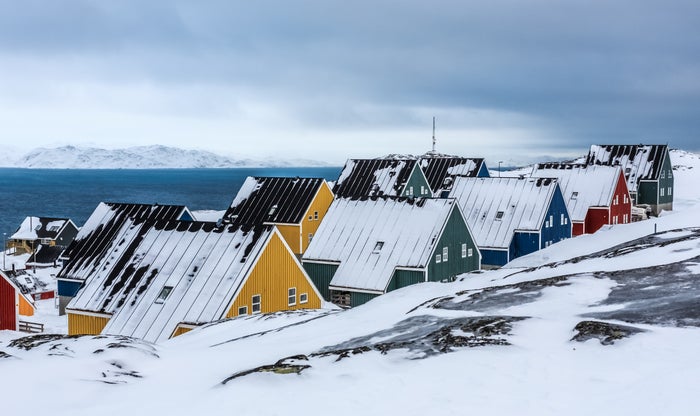 Yellow, blue, red and green inuit houses covered in snow at the fjord of Nuuk city, Greenland Yellow, blue, red and green inuit houses covered in snow at the fjord of Nuuk city, Greenland