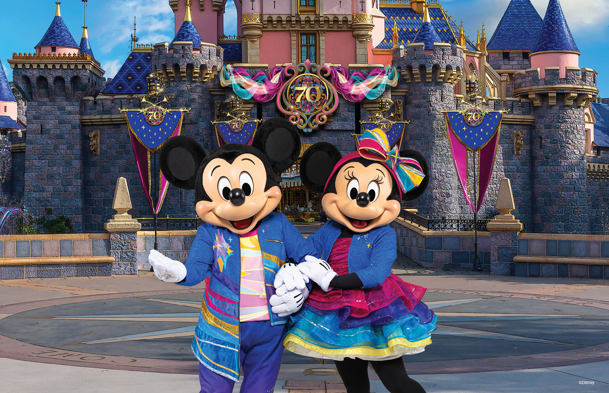 Mickey and Minnie in front of a castle with 70th anniversary decorations