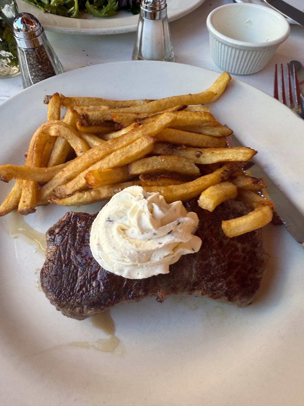 A plate of steak frites on a table at Bistro Les Amis in Manhattan