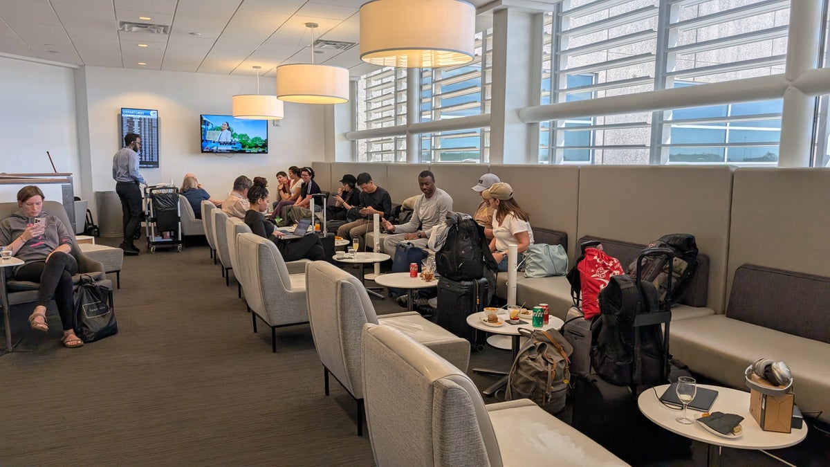 The Club MCO Terminal A booth seating with information screens