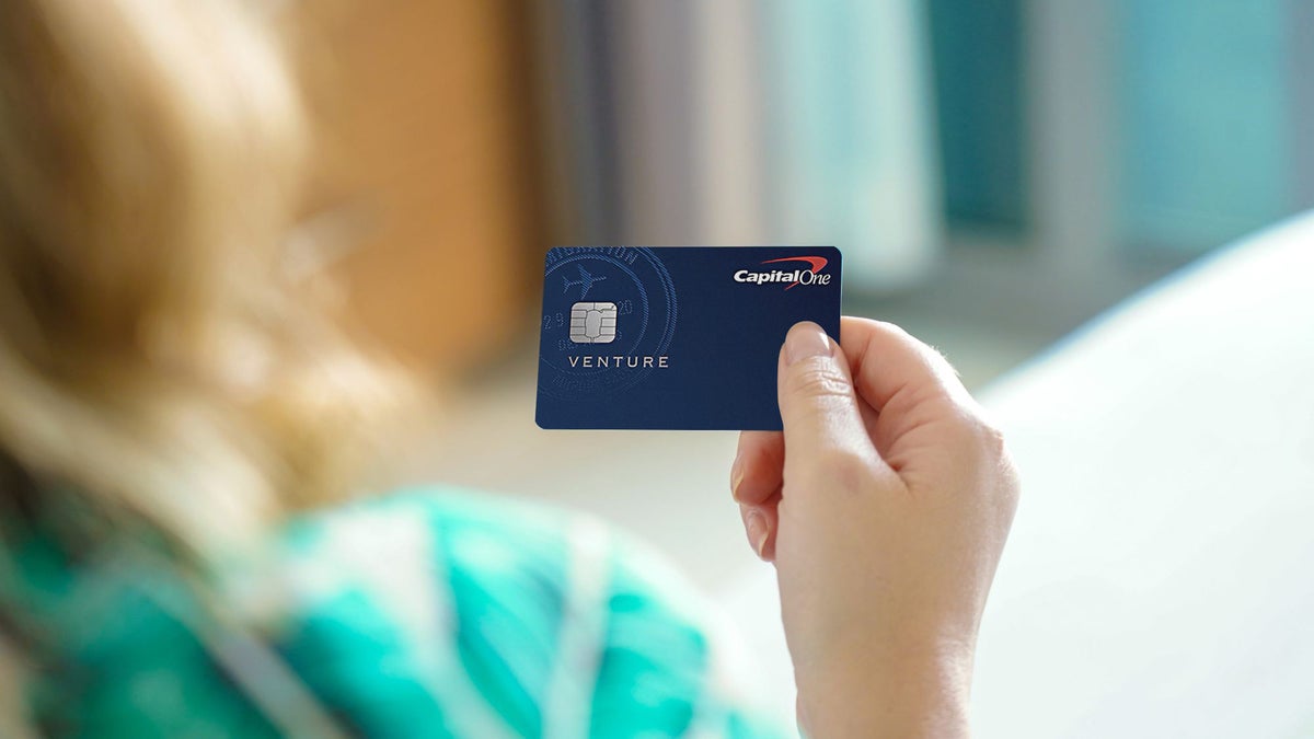 Female hand holding Capital One Venture Card Upgraded Points LLC.jpg