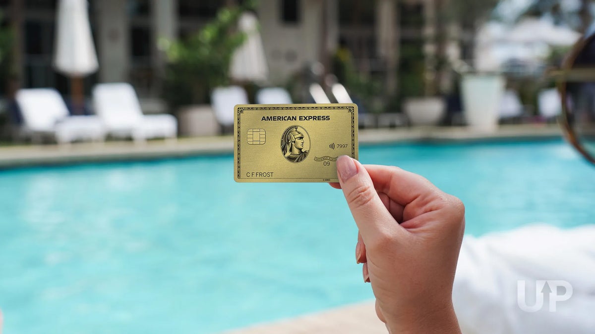 Amex Gold Card in Hand on Pool Deck Upgraded Points LLC