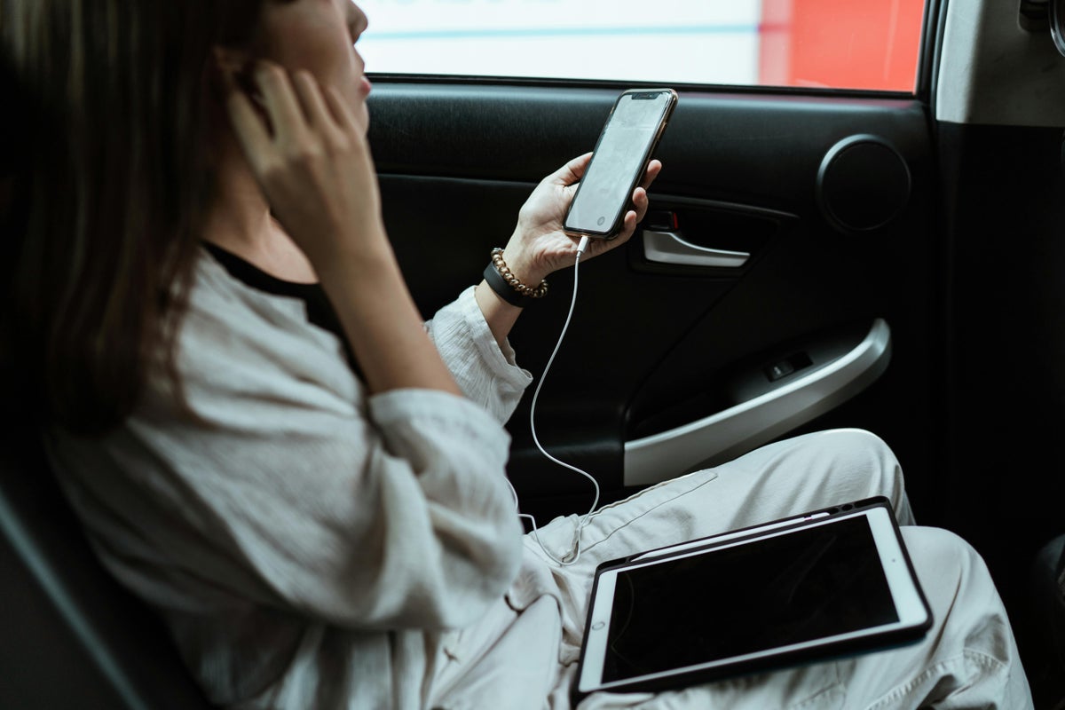 Girl in car on phone Image Credit Pexels via ketut subiyanto
