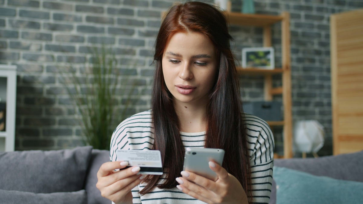 Young woman with phone and credit card