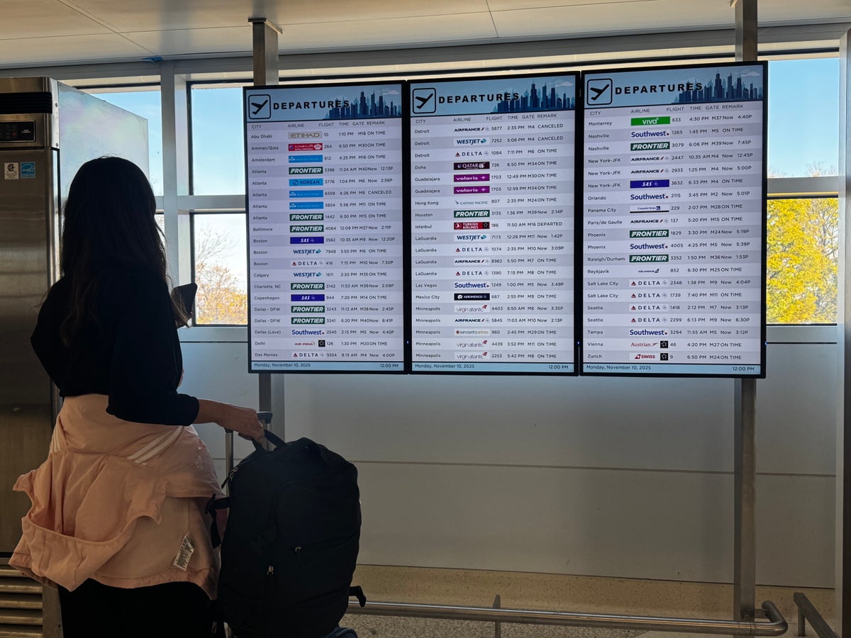 Woman at airport departures board Woman at airport departures board