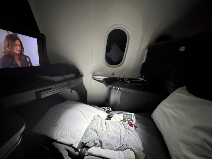 AA Flagship Suite Business Class lie flat bed watching TV AA Flagship Suite Business Class lie flat bed watching TV