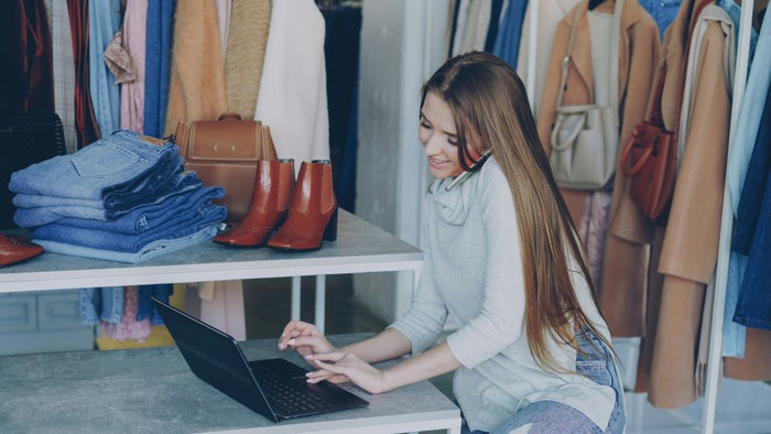 Small business owner using phone in store